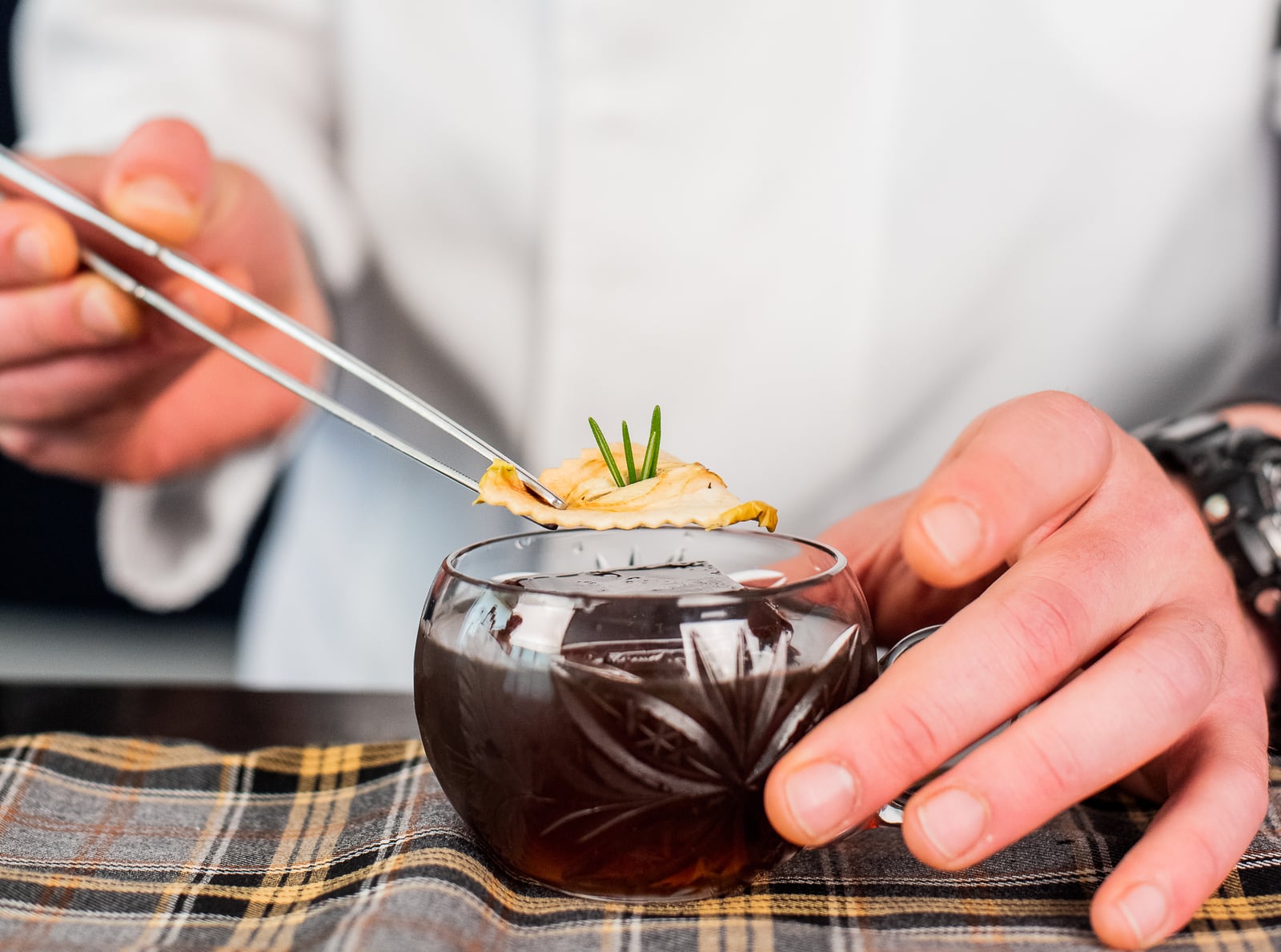 Decorul unui cocktail este așezat cu penseta